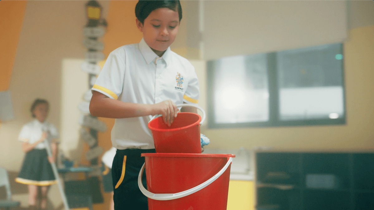 A Sunway International School student filling up a bucket of water